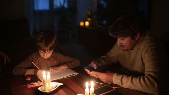 A family sheltering in place on the first level of the home in a candle-lit room