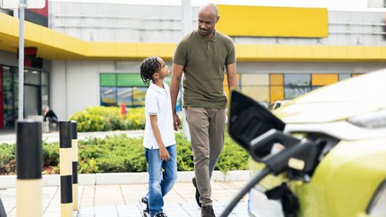 Father and son are charging the electric car