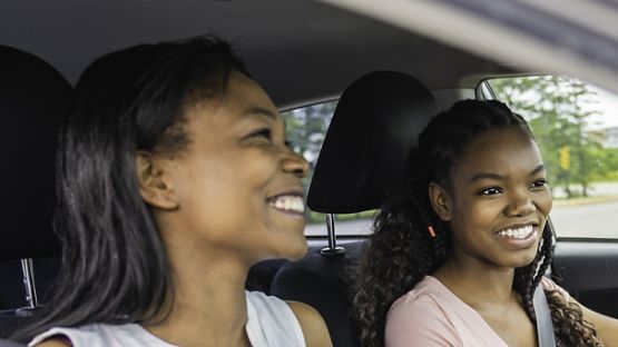 Aviva Journey app on a smartphone screen with a driver smiling, symbolizing safe driving and car insurance savings.