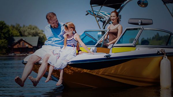 Father and daughter sitting on front of speed boat while mother watches